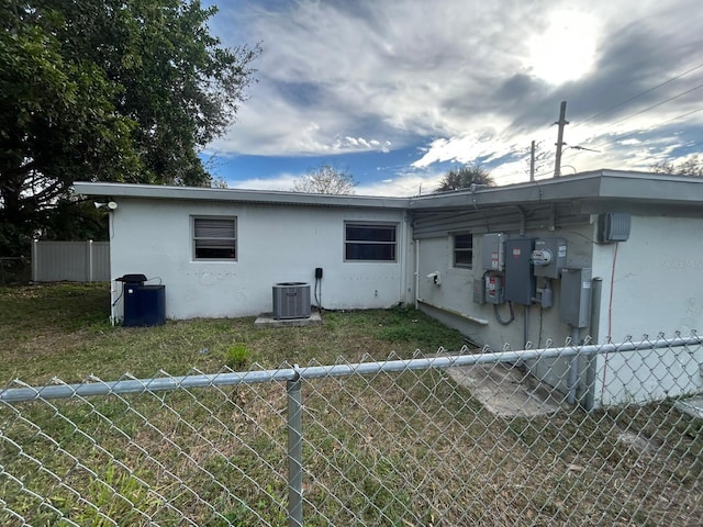 rear view of house featuring a lawn and cooling unit