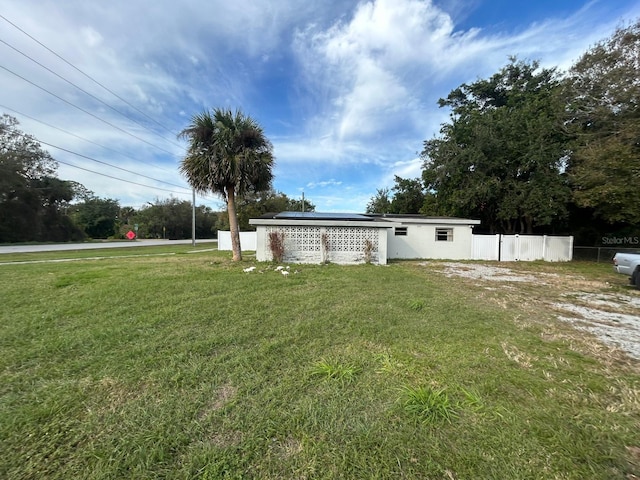 view of front of house featuring a front yard and solar panels