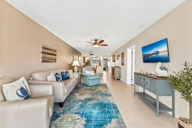 tiled living room with ceiling fan and a textured ceiling