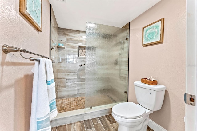 bathroom with a tile shower and toilet