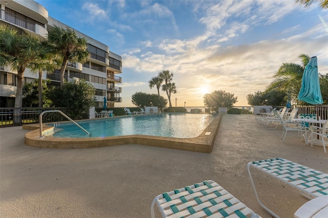 pool at dusk with a patio