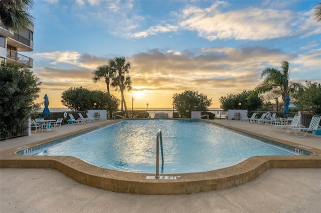 pool at dusk featuring a patio area