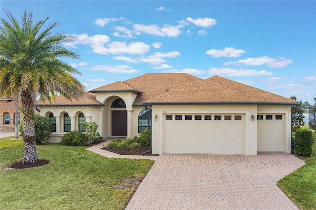 mediterranean / spanish home with a garage and a front lawn