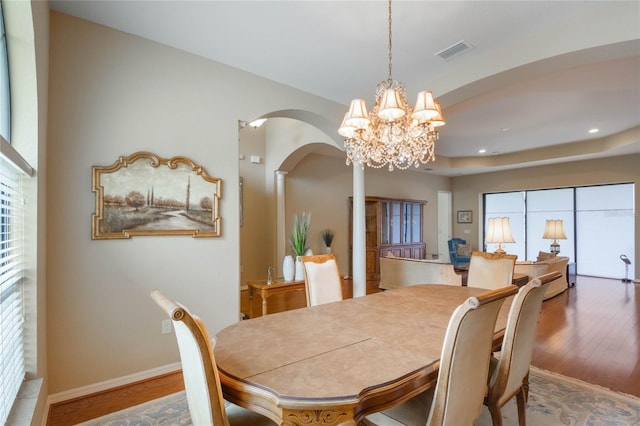 dining area featuring wood-type flooring and a chandelier