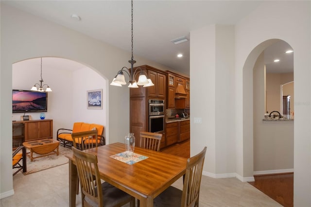 dining area featuring a chandelier and light tile patterned flooring