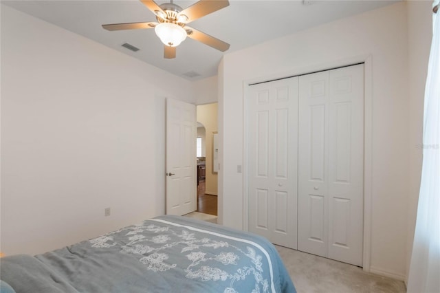 carpeted bedroom featuring ceiling fan and a closet