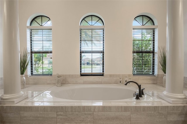 bathroom with ornate columns and tiled bath