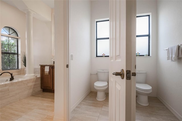 bathroom with toilet, a relaxing tiled tub, tile patterned floors, and ornate columns