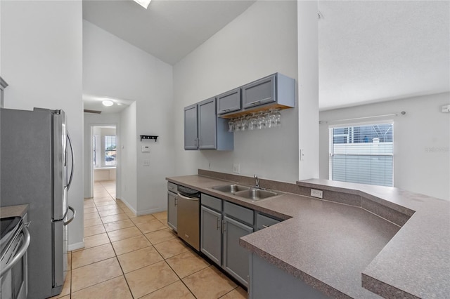 kitchen with light tile patterned floors, sink, gray cabinetry, and stainless steel appliances