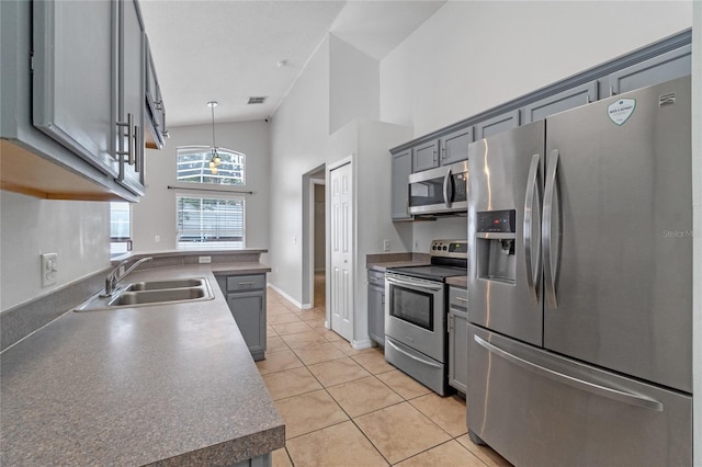 kitchen featuring gray cabinets, sink, hanging light fixtures, stainless steel appliances, and light tile patterned floors