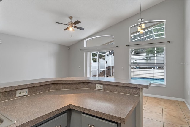 kitchen with ceiling fan, pendant lighting, light tile patterned floors, and lofted ceiling