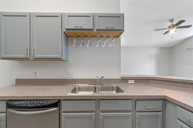 kitchen featuring sink, dishwashing machine, and gray cabinetry