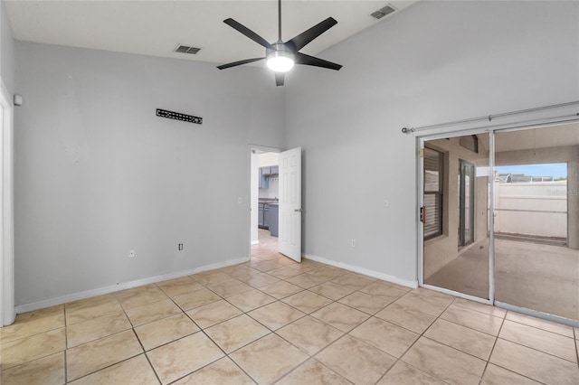 unfurnished bedroom with ceiling fan, light tile patterned floors, a closet, and high vaulted ceiling