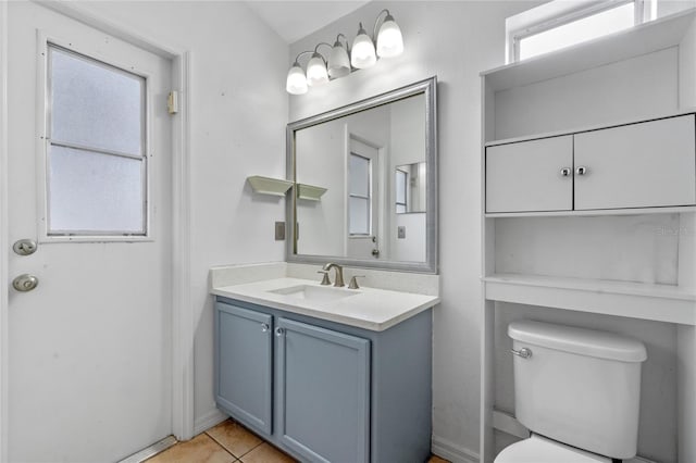 bathroom featuring toilet, a wealth of natural light, tile patterned floors, and vanity