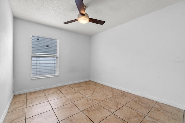 tiled empty room with ceiling fan and a textured ceiling