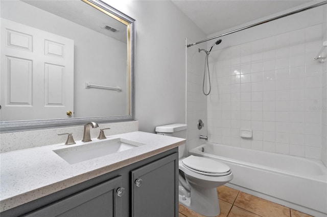 full bathroom with toilet, vanity, tile patterned flooring, and tiled shower / bath combo