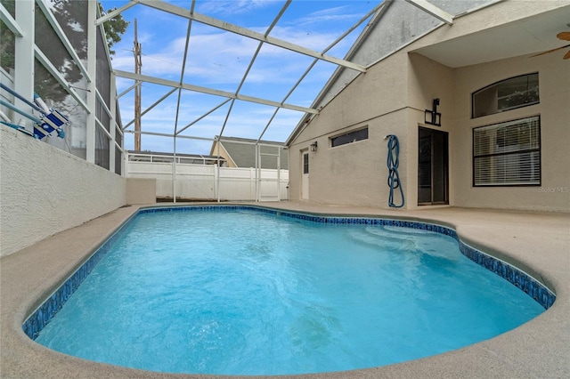 view of swimming pool featuring a lanai and a patio