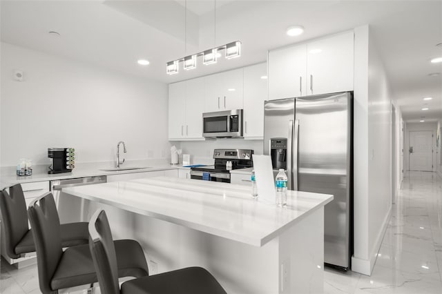 kitchen featuring sink, hanging light fixtures, white cabinets, and stainless steel appliances