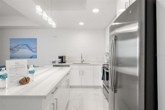 kitchen with pendant lighting, sink, white cabinetry, and stainless steel appliances