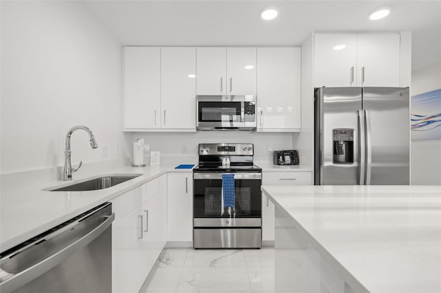 kitchen with appliances with stainless steel finishes, white cabinets, and sink