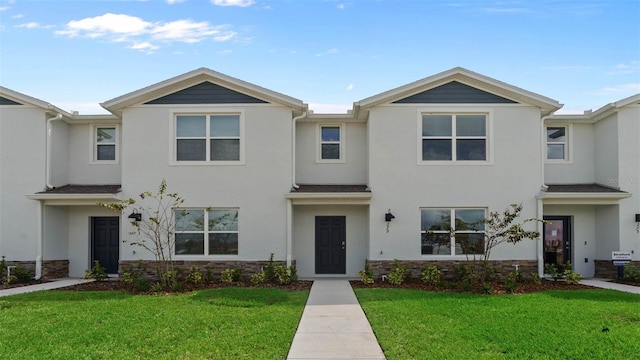 townhome / multi-family property featuring a front yard