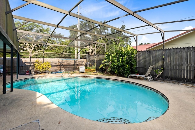 view of pool with a patio and glass enclosure