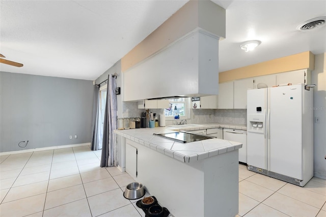 kitchen featuring white appliances, tile counters, white cabinetry, tasteful backsplash, and kitchen peninsula