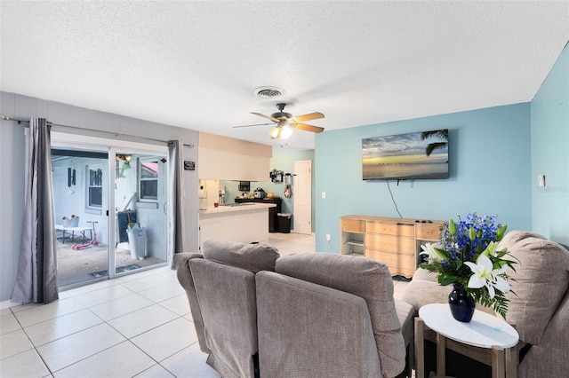 tiled living room with ceiling fan and a textured ceiling