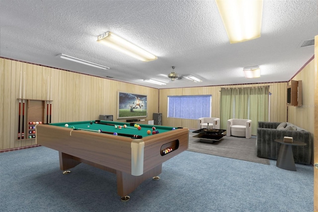 rec room featuring wooden walls, ceiling fan, carpet, pool table, and a textured ceiling