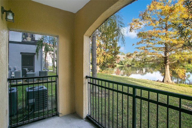 balcony featuring a water view and central AC unit