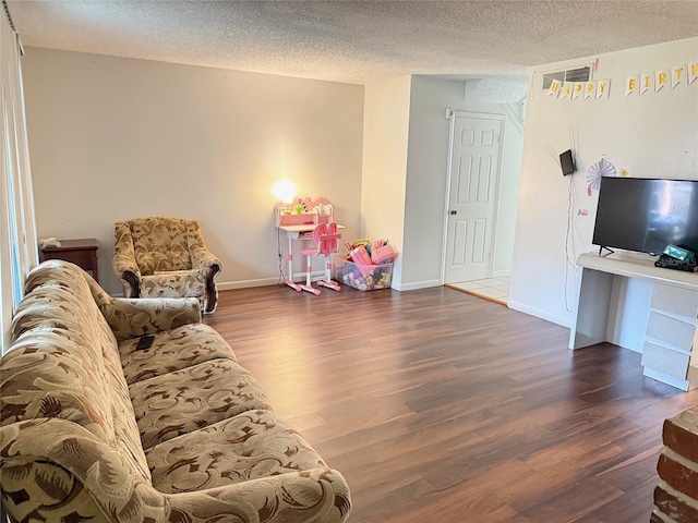 living room with a textured ceiling and dark hardwood / wood-style flooring