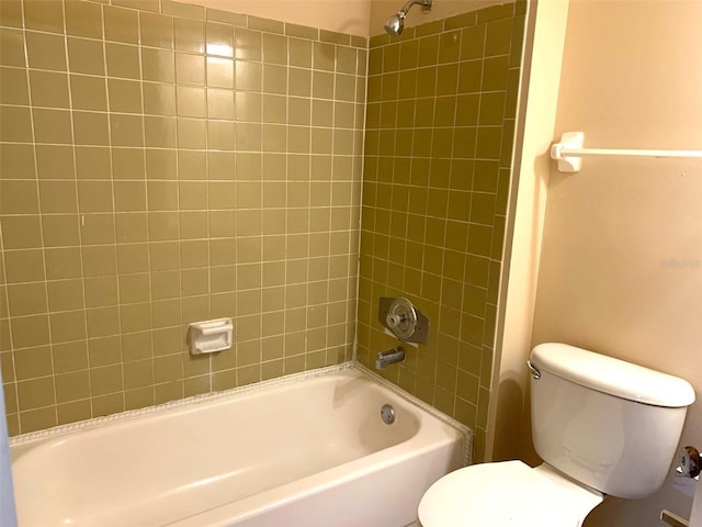 bathroom with toilet and tiled shower / bath