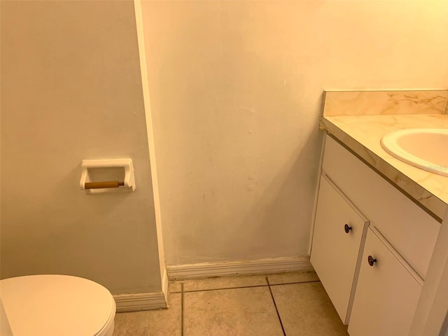 bathroom with toilet, vanity, and tile patterned floors