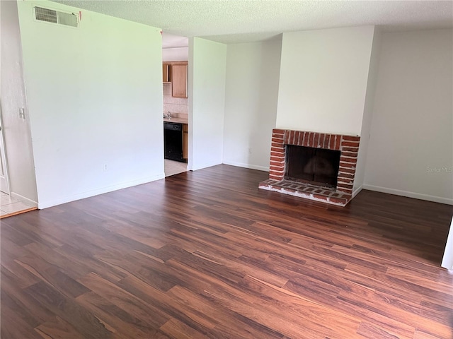 5123 Picadilly Circus Ct Unit 2, Orlando, FL 32839 - unfurnished living room featuring dark wood-style floors, a fireplace, baseboards, and a textured ceiling