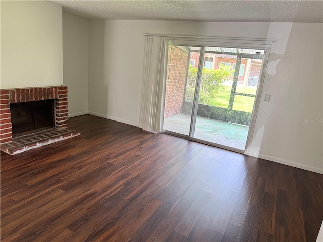 5123 Picadilly Circus Ct Unit 2, Orlando, FL 32839 - unfurnished living room with dark wood finished floors, a fireplace, baseboards, and a textured ceiling