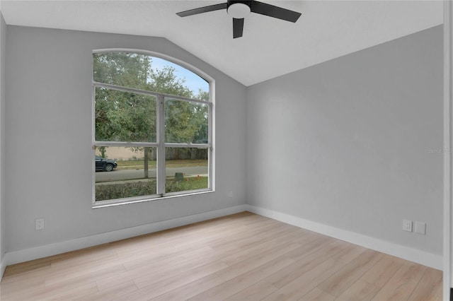 empty room featuring lofted ceiling, ceiling fan, light wood finished floors, and baseboards