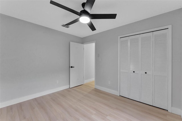 unfurnished bedroom with a closet, light wood-type flooring, visible vents, and baseboards