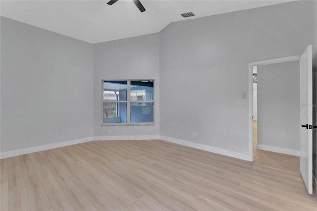 unfurnished room featuring visible vents, vaulted ceiling, ceiling fan, light wood-type flooring, and baseboards