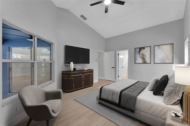 bedroom featuring light wood-style floors, visible vents, high vaulted ceiling, and a ceiling fan