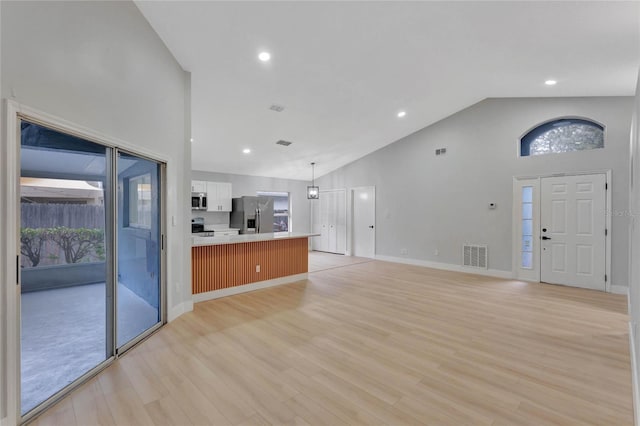 unfurnished living room with baseboards, visible vents, light wood-type flooring, high vaulted ceiling, and recessed lighting