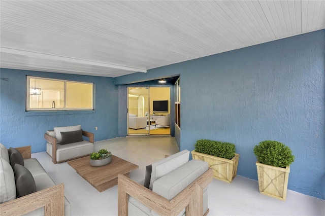 living area with finished concrete floors and a textured wall