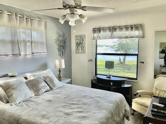 bedroom featuring ceiling fan and a textured ceiling