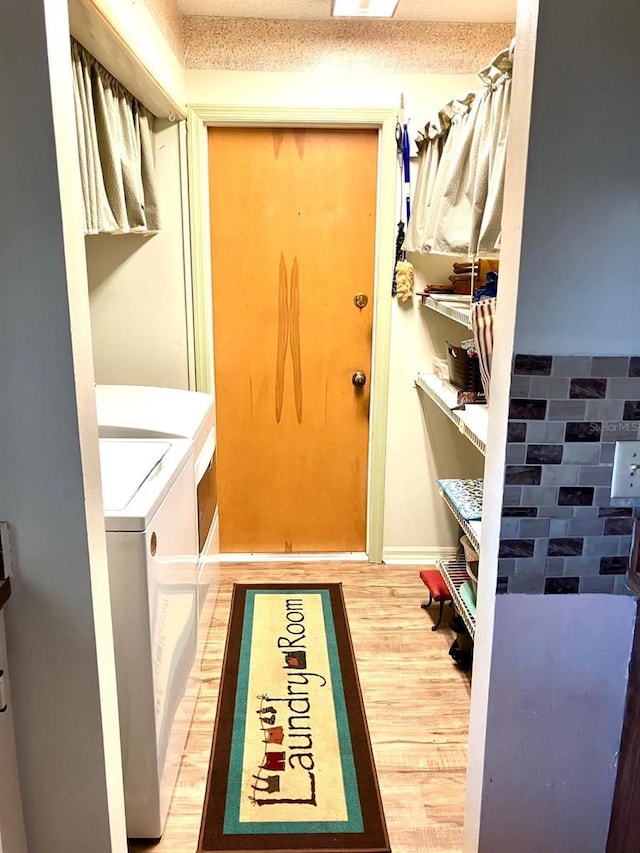 washroom featuring separate washer and dryer, hardwood / wood-style flooring, and a textured ceiling