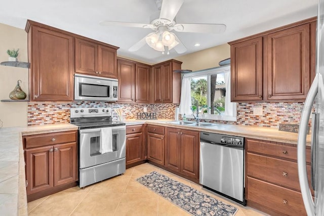 kitchen with decorative backsplash, appliances with stainless steel finishes, sink, and light tile patterned flooring