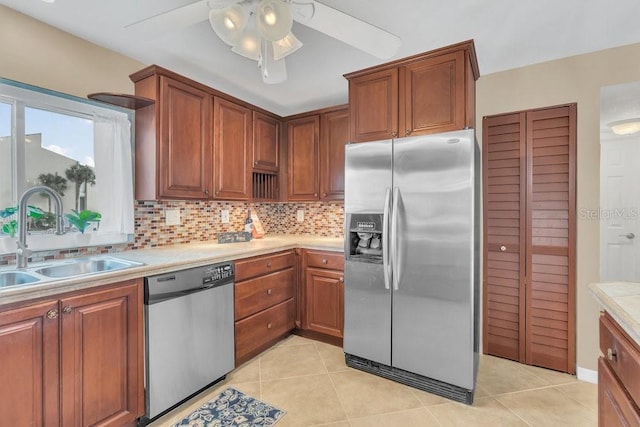 kitchen with tasteful backsplash, ceiling fan, sink, light tile patterned flooring, and appliances with stainless steel finishes