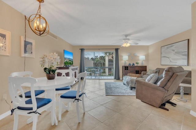 tiled living room with ceiling fan with notable chandelier