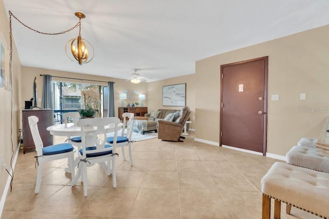 dining area with light tile patterned floors and ceiling fan with notable chandelier