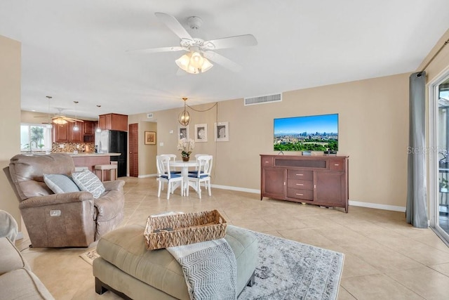 living room featuring ceiling fan and light tile patterned floors