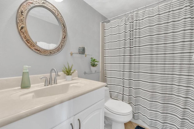 bathroom with toilet, tile patterned flooring, vanity, and curtained shower