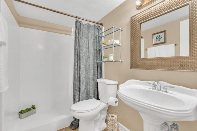 bathroom featuring sink, toilet, and a shower with curtain